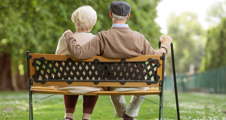 Rear view shot of a senior couple sitting on a wooden bench in the park
